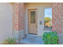 Elegant front door with decorative glass and brick accents providing a welcoming entrance to the home at 12607 W Highland Ave, Litchfield Park, AZ 85340
