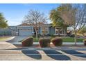 Charming single-story home featuring a gray exterior, well-manicured lawn, and a paved driveway leading to a two-car garage at 12962 N 145Th Ave, Surprise, AZ 85379