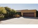 Garage featuring a desert landscaped yard and large concrete driveway at 1301 Coyote Pass, Carefree, AZ 85377