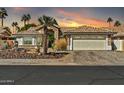 Charming single-story home featuring a stone facade, desert landscaping and colorful sunset at 14266 W Kiowa Trl, Surprise, AZ 85374