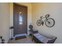 Welcoming front porch with decorative wall art, bench, and a stylish brown front door at 1775 E Tangelo Pl, Queen Creek, AZ 85140
