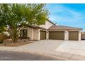 Lovely home with three-car garage, desert landscaping, and a mature tree providing shade at 18621 W Missouri Ave, Litchfield Park, AZ 85340