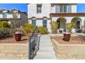 Beautiful two-story home with a welcoming front patio and landscaped garden leading to the entry at 20728 W Legend Trl, Buckeye, AZ 85396