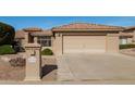 Attractive single-level home with a two-car garage, desert landscaping, and sidewalk access at 23732 S Glenburn Dr, Sun Lakes, AZ 85248