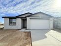 A single-story home with a two car garage, neutral paint, and a well-maintained front yard at 2447 E Spur Dr, San Tan Valley, AZ 85140