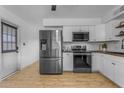 Bright kitchen with stainless steel appliances, white cabinets, and wood grain floors at 248 S 95Th Pl, Chandler, AZ 85224