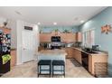 Well-lit kitchen featuring modern appliances, granite countertops, tile backsplash and center island with seating at 26111 W Yukon Dr, Buckeye, AZ 85396