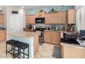 Well-lit kitchen featuring modern appliances, granite countertops, tile backsplash and center island with seating at 26111 W Yukon Dr, Buckeye, AZ 85396
