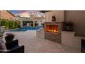 Cozy outdoor patio area featuring a brick fireplace and views of a luxurious pool at 2733 E Virginia St, Gilbert, AZ 85296