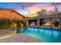 Backyard pool featuring a pergola, fire features, and ambient lighting, ideal for outdoor entertaining at 2733 E Virginia St, Gilbert, AZ 85296