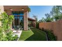 Backyard view of patio area, artificial turf, mature trees and desert landscaping, creating a serene outdoor space at 4434 E Camelback Rd # 128, Phoenix, AZ 85018