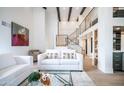 Bright living room featuring modern furniture, a glass coffee table, and staircase in the background at 4434 E Camelback Rd # 128, Phoenix, AZ 85018