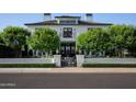 Elegant two-story home boasts a manicured lawn, gated entrance, and classic architectural details on a tree-lined street at 5915 E Calle Del Sud --, Phoenix, AZ 85018