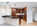 Stylish kitchen with dark wood cabinets, stainless appliances, and a breakfast bar at 7175 E Camelback Rd # 307, Scottsdale, AZ 85251