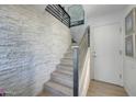 Modern staircase with stylish railing and stone accent wall, adding architectural flair to the interior at 7272 E Gainey Ranch Rd # 27, Scottsdale, AZ 85258