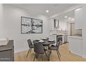 Modern dining area with seating for four, hardwood floors, and adjacent updated kitchen at 7710 E Gainey Ranch Rd # 223, Scottsdale, AZ 85258