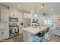 Stylish kitchen featuring stainless steel appliances, white cabinetry, a center island with seating, and modern pendant lighting at 778 E Harper St # 101, Gilbert, AZ 85297