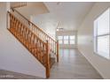 Bright entryway showcasing wood staircase, light gray flooring, and plenty of natural light at 9325 W Hazelwood St, Phoenix, AZ 85037
