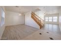 Spacious living room boasts light gray floors, neutral paint, and seamless flow to other spaces at 9325 W Hazelwood St, Phoenix, AZ 85037