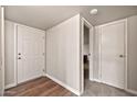 Clean entryway with a white door, wood-look flooring, and access to additional rooms at 9751 W Royal Ridge Dr, Sun City, AZ 85351