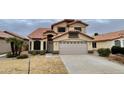 Charming home featuring a well-maintained yard and a two-car garage, with a beautiful red tile roof at 9761 W Yukon W Dr, Peoria, AZ 85382