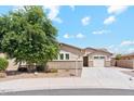 Charming single-level home featuring a lush tree, three-car garage, and desert landscaping at 10630 W Pinchot Ave, Avondale, AZ 85392