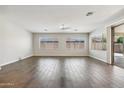 Spacious living room featuring wood-look tile flooring, a ceiling fan, and ample natural light at 10630 W Pinchot Ave, Avondale, AZ 85392