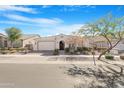 Inviting one-story home featuring a two-car garage, desert landscaping, and a charming entryway at 10633 E Sheffield Dr, Mesa, AZ 85212