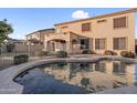 Backyard pool with a covered patio of a two-story house, complimented by mature landscaping for private outdoor living at 15635 W Montecito Ave, Goodyear, AZ 85395