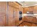 Bright kitchen featuring stainless steel appliances, wood cabinetry, and a stylish countertop at 15802 N 71St St # 604, Scottsdale, AZ 85254