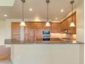 Updated kitchen features wood cabinets, granite countertops, modern appliances, and pendant lighting at 15802 N 71St St # 604, Scottsdale, AZ 85254