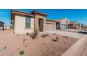 Single-story home with desert landscaping, a stone-accented entryway, and an attached two-car garage at 20660 N Confetti Ct, Maricopa, AZ 85138