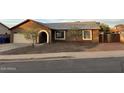 Single-story house featuring neutral stucco, a gray roof, and desert landscaping at 304 E Madison St, Avondale, AZ 85323