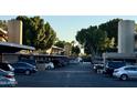 Exterior shot of well-maintained parking area with mature trees and building facade at 6125 E Indian School Rd # 216, Scottsdale, AZ 85251