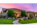 Beautiful single-story home featuring lush landscaping, decorative rock, and a brick pathway at 9955 E Celtic Dr, Scottsdale, AZ 85260