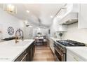 Modern kitchen with white cabinets, stainless steel appliances, quartz countertops and gold hardware at 10215 E Hillery Dr, Scottsdale, AZ 85255