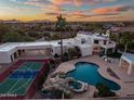 Aerial view showcasing a pool, spa, sport court, and covered parking on this desert home at 10301 N 128Th St, Scottsdale, AZ 85259