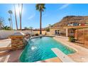 Sparkling pool featuring a diving board, rock waterfall feature and surrounding desert views at 1031 W Indian Hills Pl, Phoenix, AZ 85023