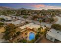 Sunset aerial view of home with pool, covered patio, palm trees, and mountain views at 11041 N 44Th St, Phoenix, AZ 85028