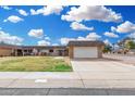 Inviting single-story home featuring a well-manicured lawn and an attached two-car garage at 11139 W Cameo Dr, Sun City, AZ 85351