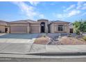 Single story home featuring low maintenance desert landscaping with a three car garage in a residential neighborhood at 11256 S Hopi Dr, Goodyear, AZ 85338