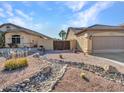 Landscaped front yard with desert landscaping, rock features, and a desert design at 11256 S Hopi Dr, Goodyear, AZ 85338