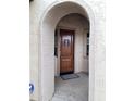 The entry to the home showcases a sturdy wooden door with decorative hardware at 12733 W Mine Trl, Peoria, AZ 85383