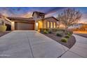 Lovely Tuscan-style home with an attached garage, desert landscaping, and well-manicured shrubs in the front yard at 13719 W Creosote Dr, Peoria, AZ 85383