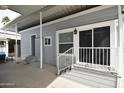 Exterior view of the house with covered entrance, steps with white railings, and a welcoming doormat at 17200 W Bell Rd # 958, Surprise, AZ 85374