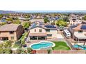 A bird's-eye view showcasing the backyard's pool, mini-golf, desert landscape, and neighborhood at 18225 W Mackenzie Dr, Goodyear, AZ 85395