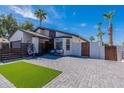 A welcoming single-story home with a cozy sitting area, modern fence, and lush artificial turf at 1830 N 87Th Ter, Scottsdale, AZ 85257