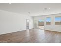 Expansive living room boasts wood-look flooring and bright natural light from a sliding door and windows at 18848 E Bruno Dr, Gold Canyon, AZ 85118