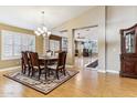 Elegant dining room with a chandelier, hardwood floors, and an open view to the living area at 19927 N 108Th Ln, Sun City, AZ 85373