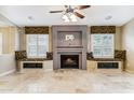 Bright living room featuring a stylish fireplace, custom window seats, and ample natural light at 19927 N 108Th Ln, Sun City, AZ 85373